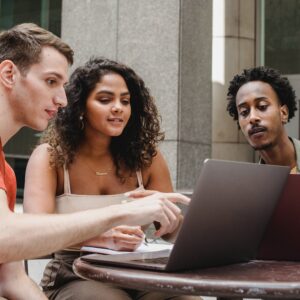 3 people looking at laptop