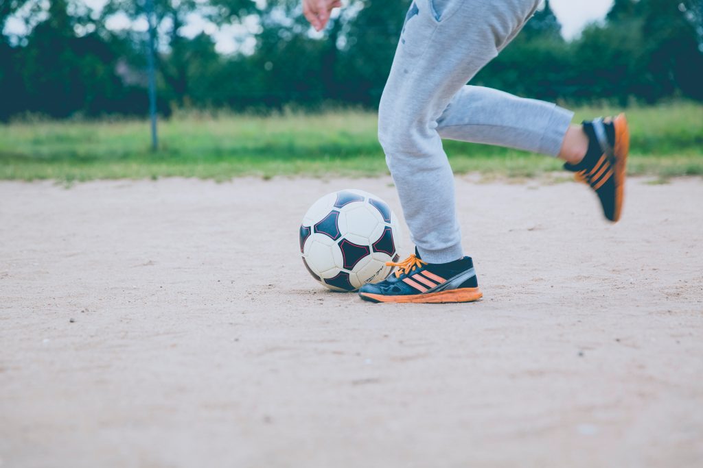 Boy playing football - Sport is good for mental health